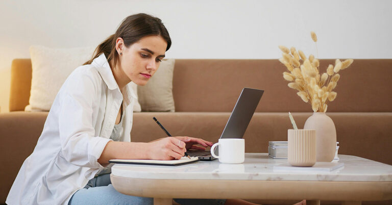Candidate taking notes in front of computer to prepare for a pre-recorded video interview