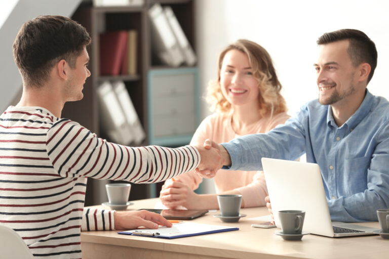 Two HR professionals and a candidate shaking hands