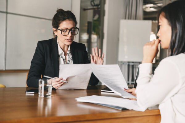 HR Director in a black blazer asking interview questions to screen for toxic employees