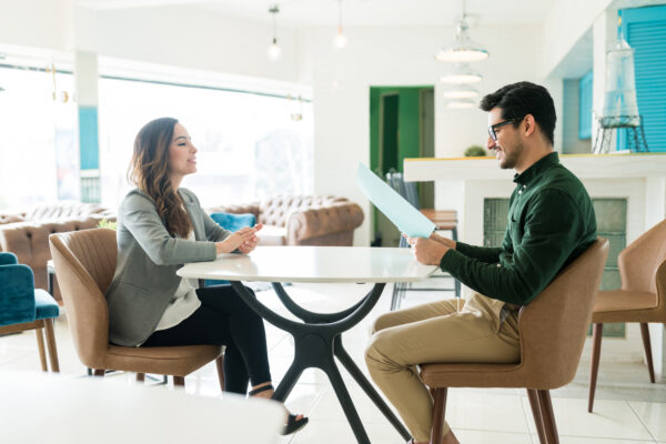 Two people sitting across from each other engaged in an interview process