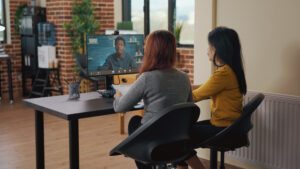 Employees watching employee development training on a desktop monitor